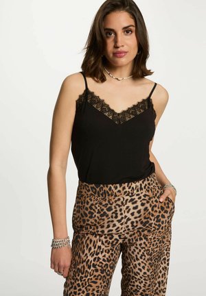 Top negro con detalles de encaje, combinado con pantalones de pierna ancha de estampado de leopardo. Presenta tirantes finos y bolsillos. El material parece suave y ligero.