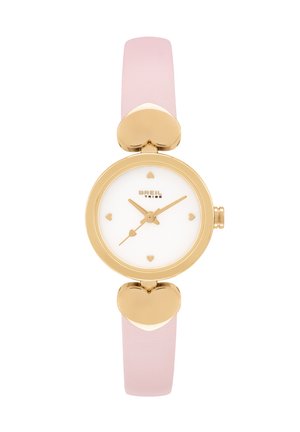 Montre dorée avec un cadran blanc rond, des index en forme de cœur et un bracelet en cuir rose clair. Ornement en forme de cœur sur le boîtier.