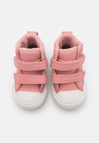 Zapatillas altas rosas con dos correas de velcro, un suave forro de felpa y una suela de goma blanca con patrones texturizados.