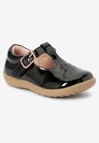 Schwarze Lackleder-Mary-Jane-Schuhe mit pinkem Innenfutter, verstellbarem Schnallenverschluss und Gummisohle mit strukturiertem Griffmuster.