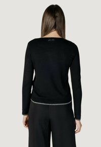 Maglione nero a maglia con maniche lunghe, scollatura rotonda e bordatura metallica lungo l'orlo. Logo "LIU JO" sulla parte superiore della schiena.