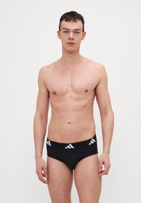 Schwarze Herrenunterwäsche aus weichem Material mit perfektem Sitz. Mit einem schwarzen Bund mit weißen Streifen und Logoakzenten.