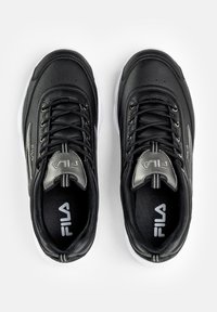 Czarne sportowe buty mają gładką skórzaną cholewkę, kontrastującą białą podeszwę, sznurowany design oraz srebrne logo na języku.