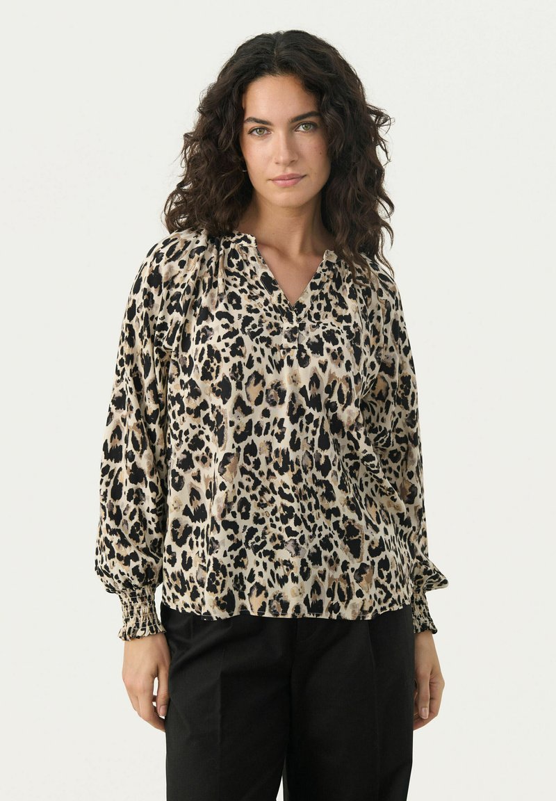 Leopardenmuster Bluse aus einem leichten, satinähnlichen Stoff. Merkmale: V-Ausschnitt, geraffte Ärmel und elastische Bündchen. Farben: Schwarz und Beige.