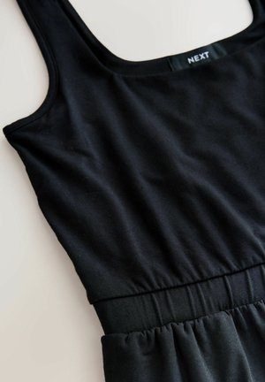 Black sleeveless dress with gathered waist and visible "NEXT" label on inner back neckline, laid flat on a light surface.