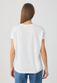 Hvid kortærmet T-shirt, let bomuldsstof, rund halsudskæring, afslappet pasform, let buet kant, glat tekstur, klassisk design.