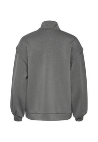 Siv sweatshirt z visokim ovratnikom, spuštenimi rameni in rebrastimi manšeti. Ima mehko teksturo in sproščen kroj.