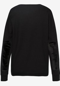 Pull noir à manches longues avec des patchs en velours sur les avant-bras, col rond et poignets côtelés, présenté de dos sur un fond uni.