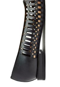 Scarpa nera aperta con punta, caratterizzata da un design a ritaglio, borchie in tonalità oro e un tacco solido. Realizzata in pelle con una finitura testurizzata.