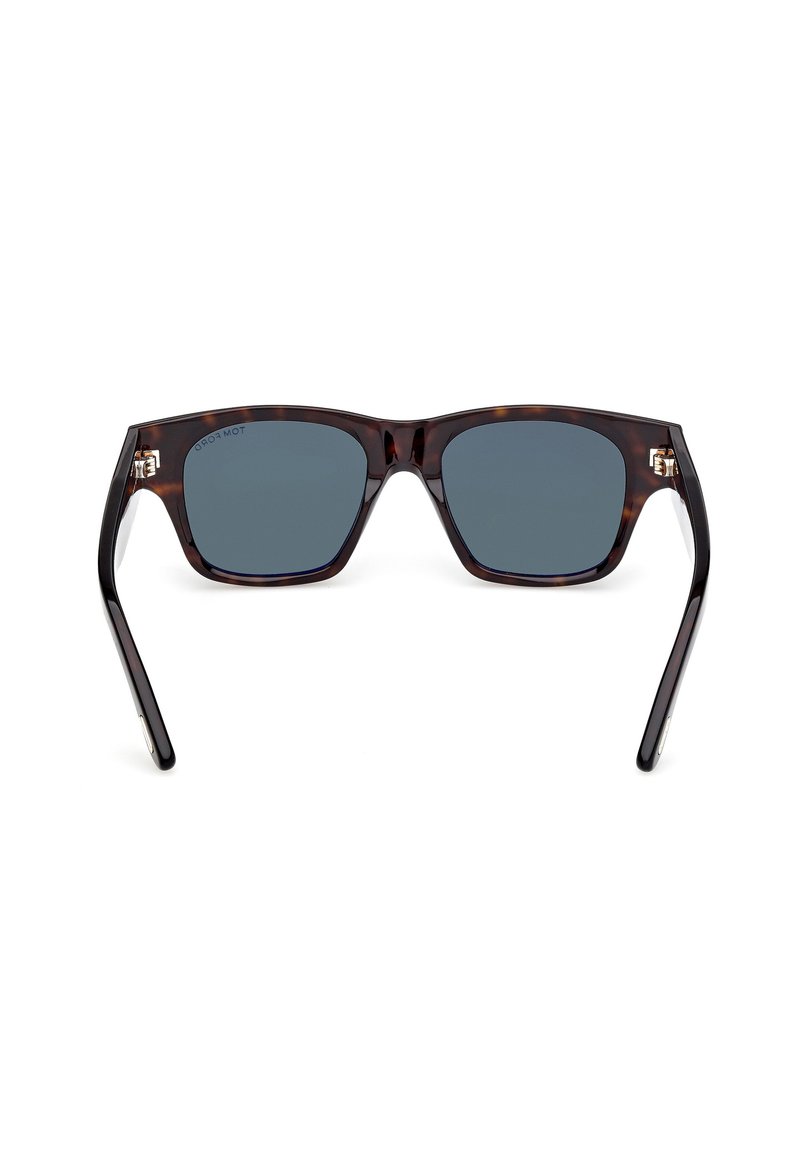 Une paire de lunettes de soleil avec une monture en écaille de tortue, des verres gris, une forme carrée et des accents en métal argenté sur les branches.