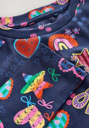 Marineblauer Rippstoff mit bunten Mustern von Herzen, Regenbögen, Sternen und Bonbonformen. Enthält kräftige Akzente in Pink, Grün und Orange.
