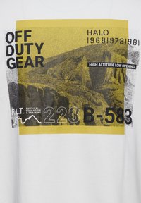 Hvid bomulds T-shirt med et grafisk tryk i gult og sort, der viser tekst: "FRI TID UDRUSTNING," "HØJ ALTITUDE LAV ÅBNING," og numeriske detaljer.