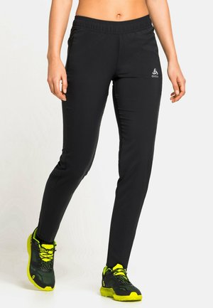 Black athletic pants with a fitted design, elastic waistband, smooth texture, featuring a small logo on the upper left leg.