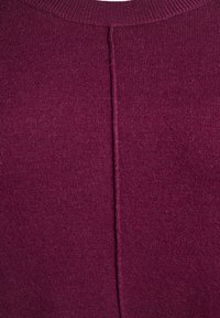 Pleteni pulover u tamnoj bordo boji, s okruglim izrezom, teksturiranom površinom i šavom koji se proteže okomito sredinom stražnje strane.