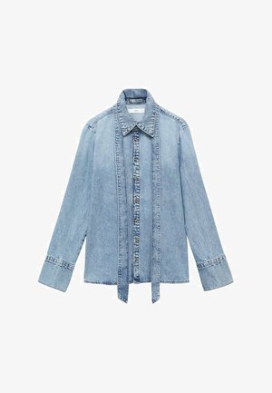 Helles blaues Denim-Hemd mit langen Ärmeln, Knopfleiste vorne, spitzem Kragen und verlängerten vertikalen Denim-Trägern entlang der Knopfleiste.