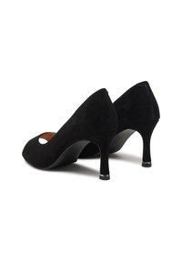 Čierne semišové lodičky na vysokom opätku s vykrojeným dizajnom, špicatou špičkou a štíhlym opätkom, ktorý má strieborný akcent na špičke.