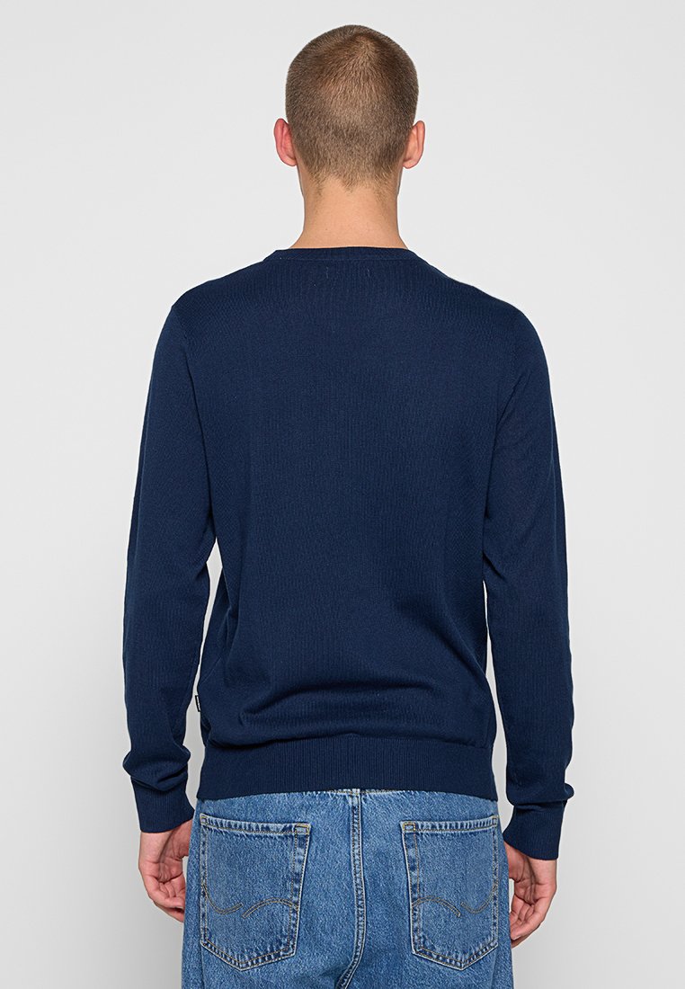 Maglione lavorato a maglia blu navy con maniche lunghe e texture a coste, dotato di scollatura tonda e orlo aderente. Vista posteriore visualizzata.