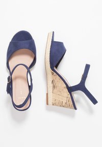 Námořnické modré semišové sandály na platformě s otevřenou špičkou, korkovým podpatkem a páskem kolem kotníku s detailem zlaté spony.