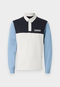 Poloko s dlouhým rukávem, které má bílé tělo, tmavě modré ramena a světle modré rukávy. Obsahuje límec a logo na prsou.