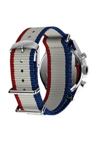 Reloj Timex con una correa de tela gris que presenta rayas rojas y azules, herrajes de metal plateado y una caja redonda de acero inoxidable.