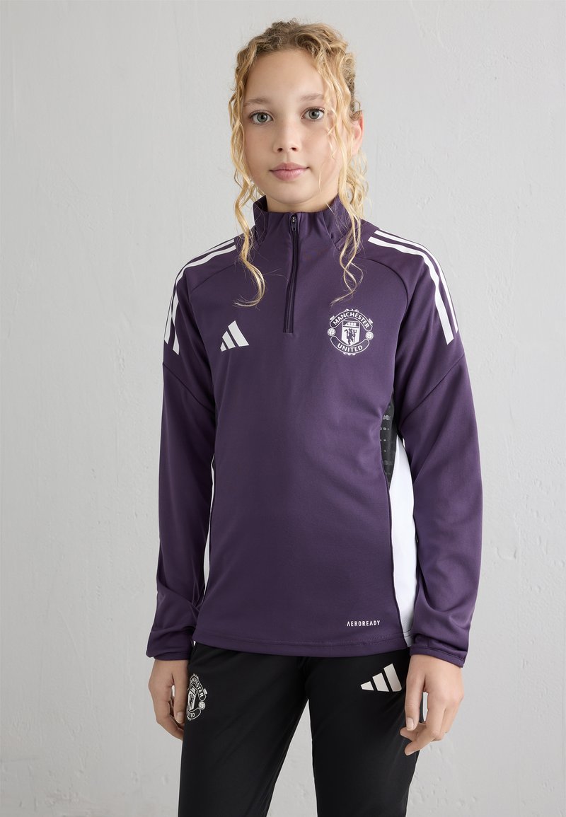Purple athletic jacket with a quarter-zip, white accents, and Manchester United logo. Paired with black pants featuring a logo and stripes.
