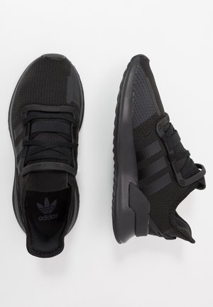 Paire de baskets de sport Adidas noires avec empeignes en mesh, trois bandes sur le côté et lacets, vues de dessus et de côté.