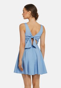 Blaues Kleid mit schwingendem Rock, ärmellosem Design und einer Schleifendetails am Rücken. Hergestellt aus weicher, glatter Stoffqualität.