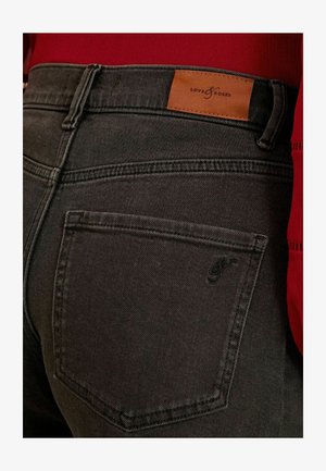 Sive traperice s smešnom kožnom etiketom na pojasu koja glasi "LOVE & ROSES". Imaju zadnji džep sa šivenim naglaskom.