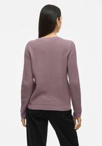 Pull en tricot lavande avec un tissu texturé, des poignets et un ourlet côtelés, doté d'un col rond classique et d'une coupe décontractée.