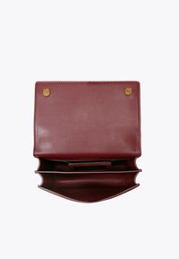 Portefeuille en cuir bordeaux avec une texture lisse. Comprend deux compartiments, une fente centrale pour cartes et des fermetures à pression en métal.