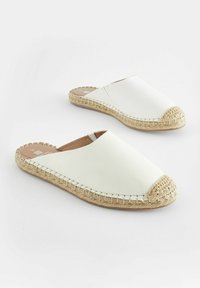 Vita läderslip-inskor med en rund halmtoffel och flätad jutesula, med en slät ovandel och enkelt design.