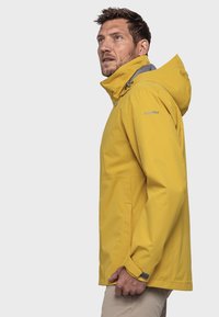 Gelbe wasserdichte Jacke mit Kapuze, grauen Akzenten, einem Frontreißverschluss und geradem Schnitt. Hergestellt aus langlebigem, leichtem Material.