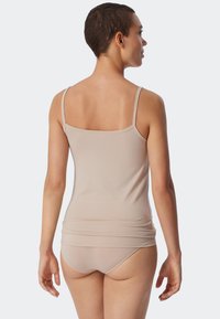 Beige ribbet tanktop med tynde stropper, der har en afslappet pasform. Sammen med matchende sømløse medium-dækning trusser, der fremhæver den bløde tekstur.
