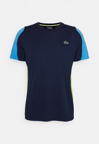 Námořnicky modré tričko s krátkým rukávem, světle modrými rameny a zelenými bočními akcenty. Na hrudi má malý vyšitý logo. Vyrobeno ze směsi bavlny.