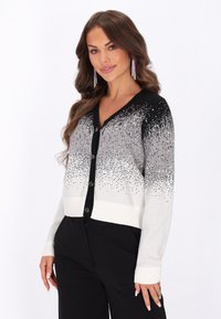 Cardigan cu gradient gri și negru, cu nasturi rotunzi, prezentând embellishments în partea de sus și un finisaj solid alb la talie și la manșete.