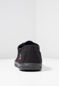 Scarpa in tessuto nero con design a scarpino basso, caratterizzata da una dettagliata ricamo di ciliegie rosse e verdi sul lato e una suola in gomma nera strutturata.