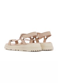 Sandales à enfiler en faux cuir beige avec plusieurs brides et une épaisse semelle en caoutchouc blanche ; offre un fond cranté et des accents réglables.