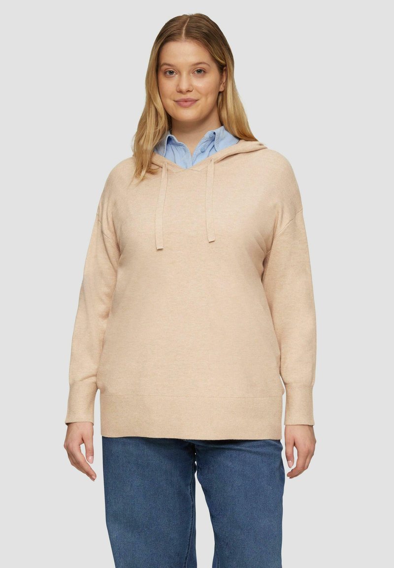 Beige Kapuzenpullover mit langen Ärmeln, gerippten Bündchen und Saum. Getragen über einem hellblauen Kragenshirt, lässiger Schnitt, weiche Textur.