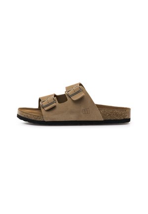 Brauner Wildleder-Sandale mit zwei verstellbaren Metallschnallen, Kork-Fußbett und schwarzer Gummisohle, seitlich auf weißem Hintergrund gezeigt.