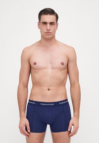 Marineblauwe herenboxerbriefs met een gladde stofafwerking, voorzien van een merk-elasitc band en een aansluitend ontwerp.