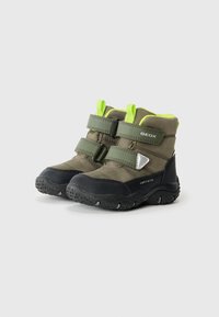 Botas impermeables verdes con suelas de goma negras, doble correa de Velcro y detalles en un verde brillante en el collar y los lazos.