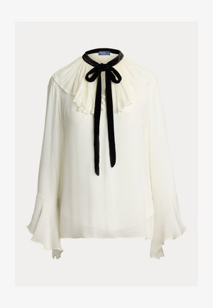 Witte blouse met een geplooide, gerimpelde kraag, zwarte fluwelen strik en drie knopen aan de voorkant. Uitlopende mouwen met een doorschijnende textuur.