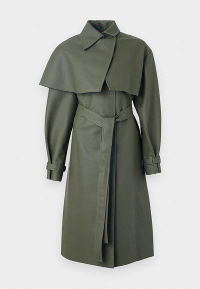 Ελαιόχρωμο παλτό με κάπα, καstructured λιτή, ζωνάκι στη μέση και μανίκια με γέμισμα. Κατασκευασμένο από λείο, υφασμάτινο υλικό.