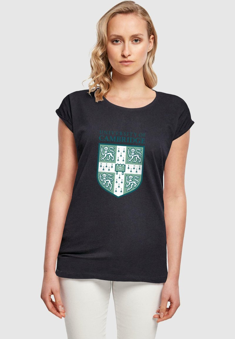 Sort bomulds T-shirt med et University of Cambridge våbenskjold i teal og hvid, med en rund halsudskæring og opfoldede korte ærmer.