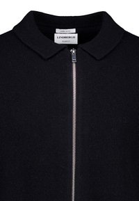 Maglione in lambswool nero con chiusura a zip, caratterizzato da un colletto polo e una vestibilità morbida. Texture liscia e dettagli di design minimalisti.