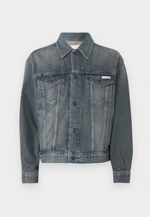 Haalistunut musta farkkutakki, jossa nappikiinnitys, kaksi rintataskua läpällä, sivutaskut sekä Calvin Kleinin logo rinnassa ja vyötäröllä.