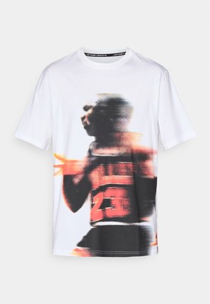 White cotton t-shirt featuring a blurred graphic print of a player in a black jersey with red accents and the number "23."
