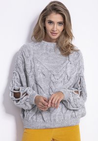 Gruby szary sweter z dzianiny z wzorem w warkocze, oversize'owy fason, ściągacz w okolicy szyi oraz wycięcia na rękawach.