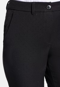 Zwarte broek van gemercerweefsel met subtiele stippenpatronen, met een sluiting met een voorste knoop en standaardzakken.