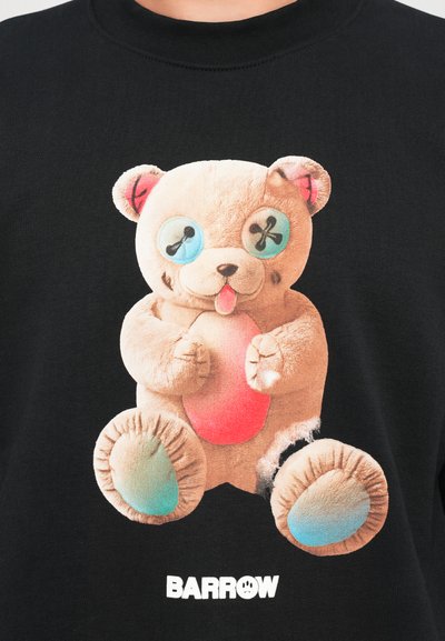Felpa nera con un grafiche di un orsetto di peluche colorato, morbido, con occhi a bottoni e pancia rosa, rifinita con bordi usurati. Logo "BARROW" in bianco.